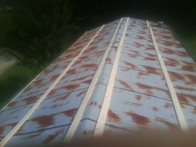 Rusted metal roof panels with new wood purlins before replacement — Storm Damage Roof Repair in Orion by Roofing Brothers