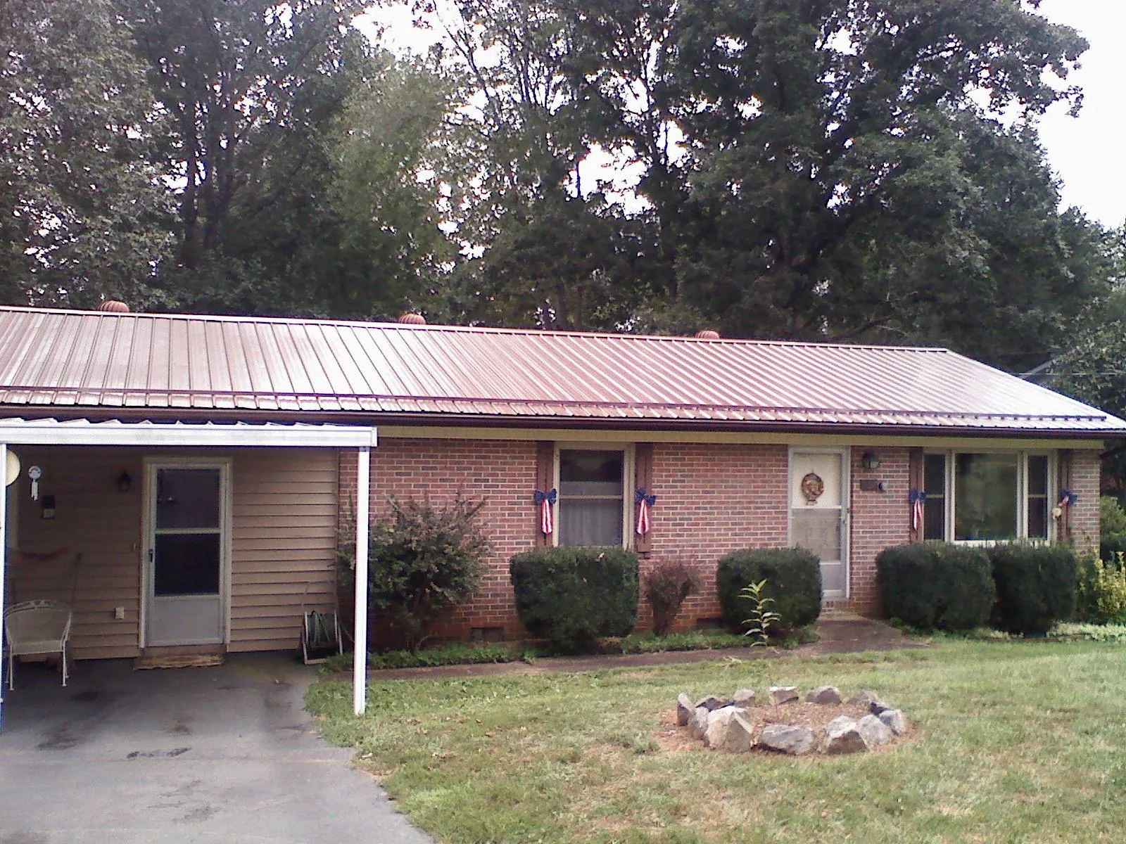 Bronze metal roof and carport on a brick ranch home — Roof Repair work by our crew in Orion