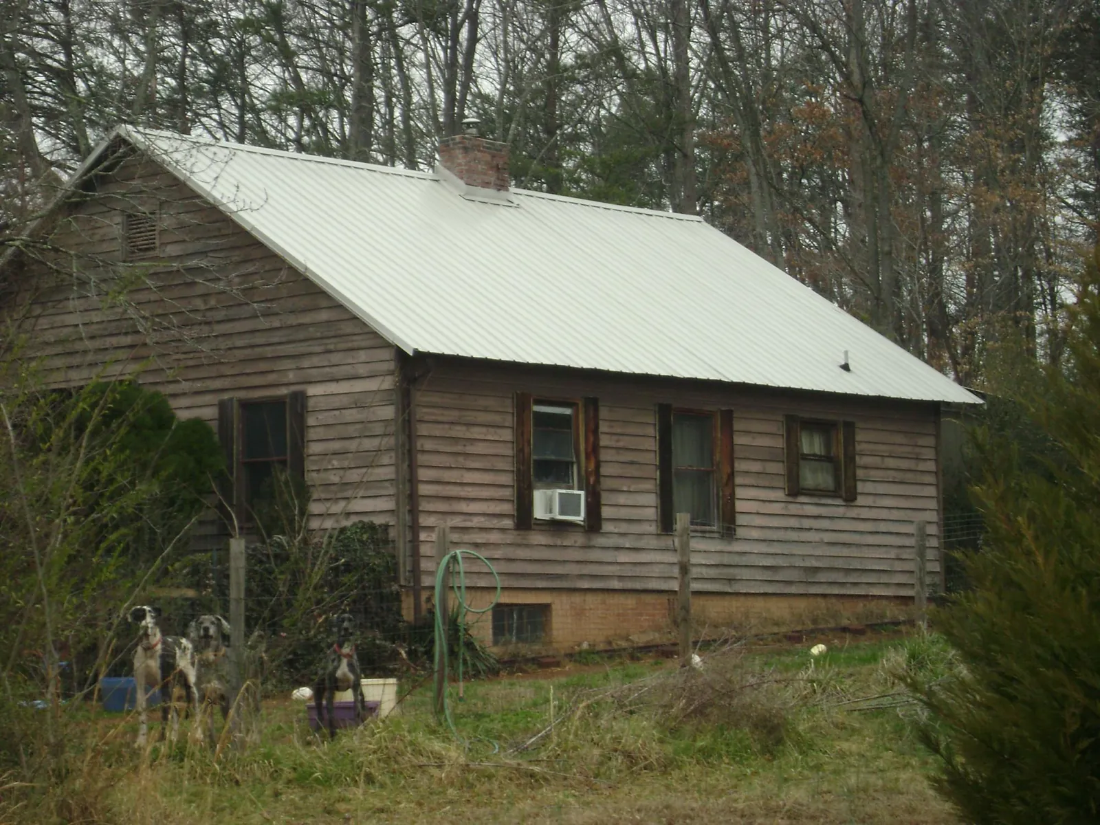 White metal roof on an old wood sided farmhouse, from a Metal Roof Installation job in Orion