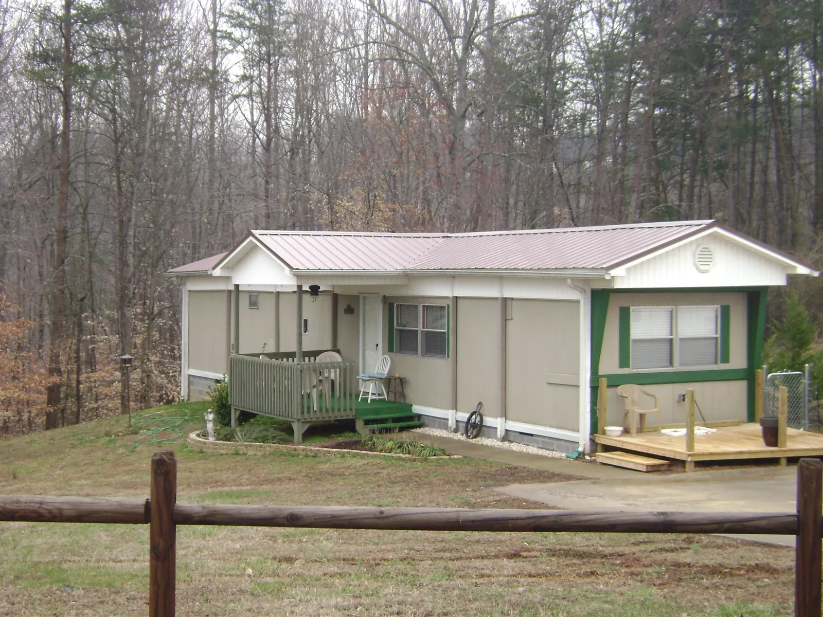 Mauve metal roof on a manufactured home with a new front deck in Orion